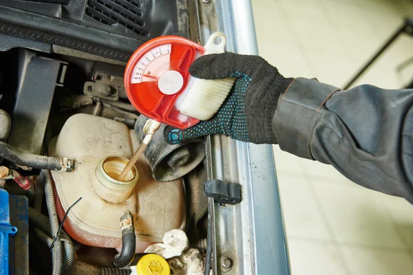 Auto mechanic tests car antifreeze liquid — Stock Photo, Image