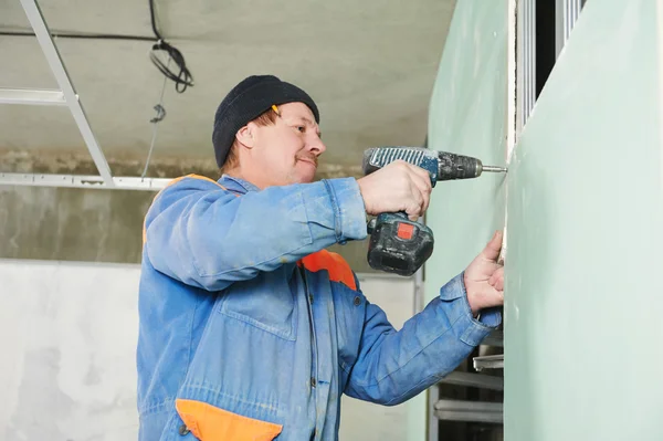 Carpenter with gypsum plasterboard and screwdriver — Stock Photo, Image