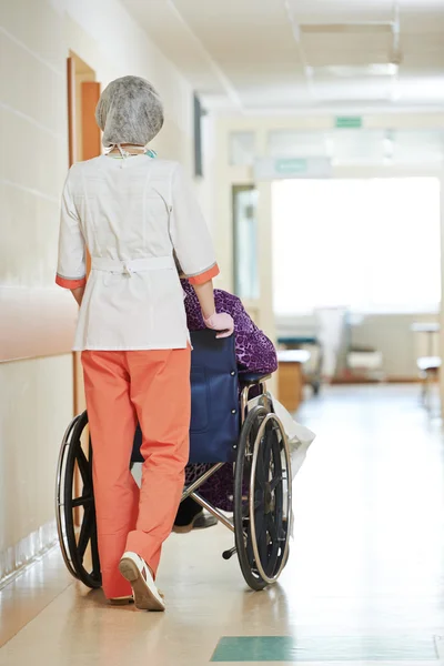 Verpleegster met oudere patiënt in rolstoel — Stockfoto