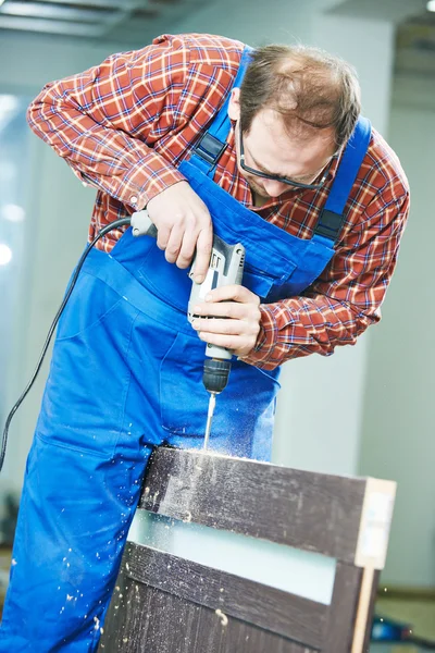 Carpenter works with drill — Stock Photo, Image