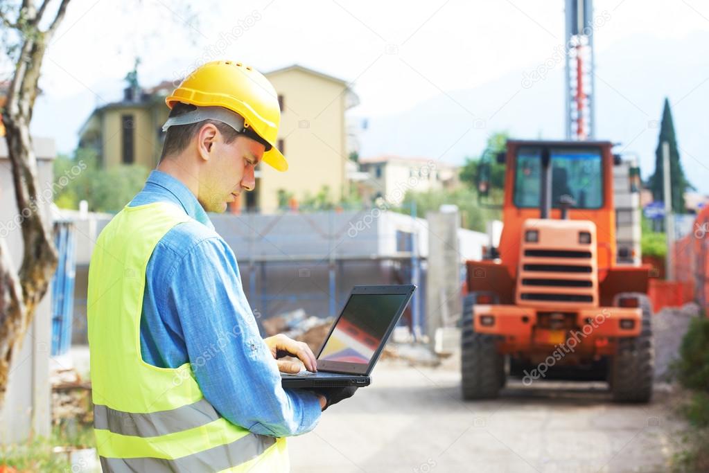 builder engineer with laptop at construction site