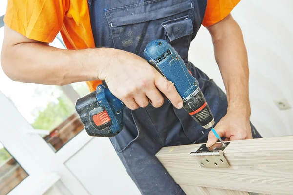 Carpenter works with scredriver — Stock Photo, Image