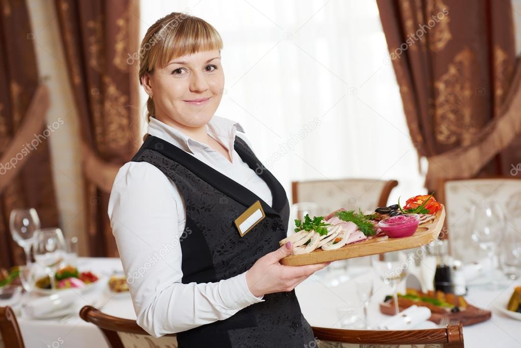 Garçonete De Restaurante Servindo Mesa Com Comida Imagem de Stock