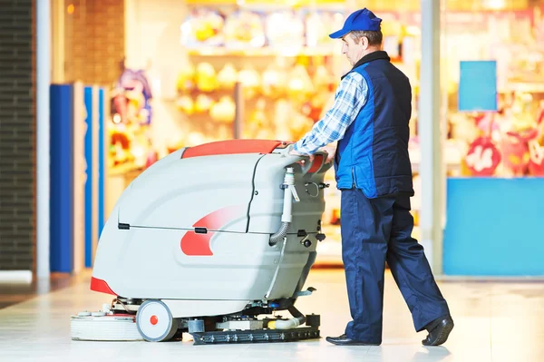 Travailleur nettoyage plancher de magasin avec machine — Photo