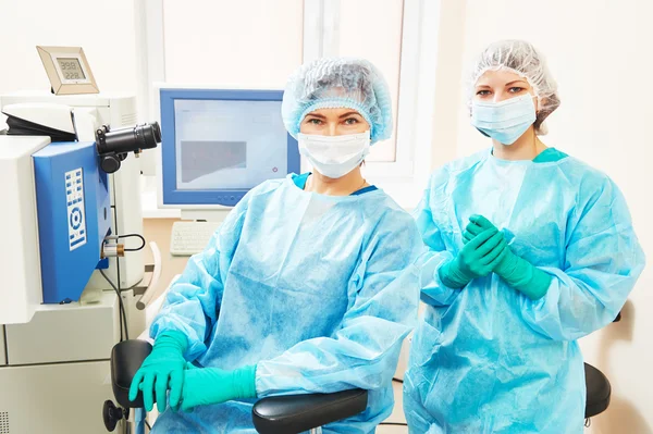 Vrouwelijke chirurg met assistent in operatie kamer — Stockfoto