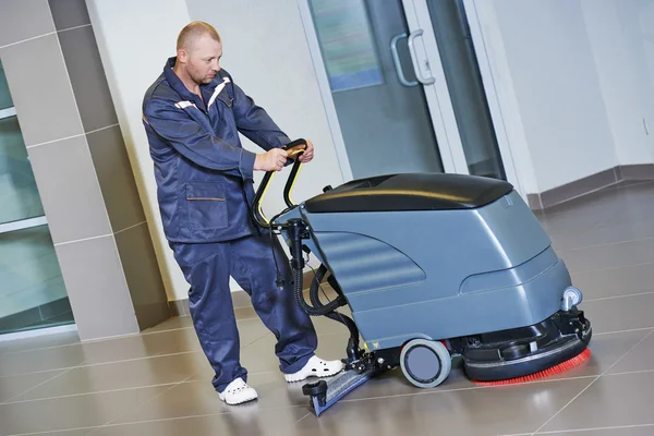 Worker cleaning floor with machine — Stock Photo, Image