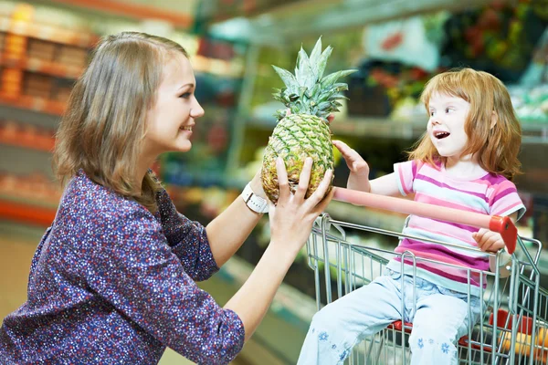 Kvinna och liten flicka shopping frukter — Stockfoto