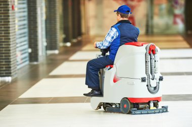 işçi mağazası zeminini makineyle temizliyor