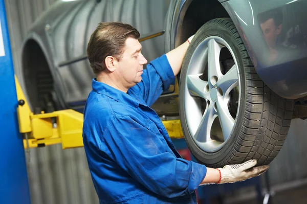 Auto mekaniker skruva bil rullar av skiftnyckel — Stockfoto