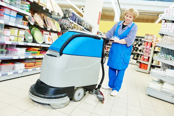 Worker cleaning store floor with machine — Stock Photo, Image