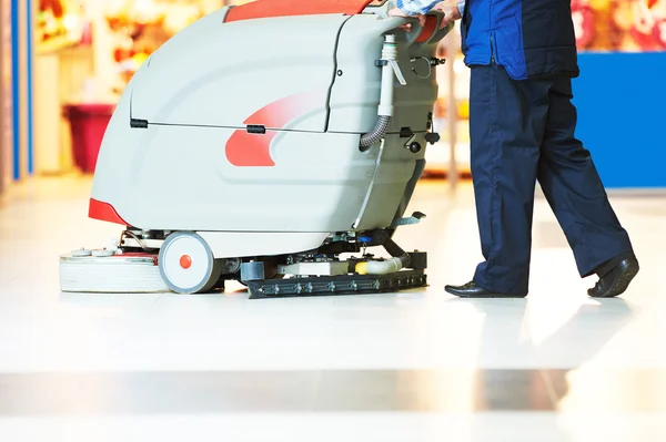 Işçi mağazası zeminini makineyle temizliyor — Stok fotoğraf