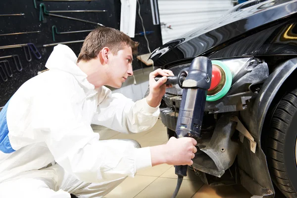 Mechanic repairing and polishing car headlight — Stock Photo, Image