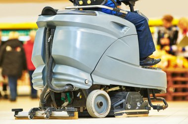 worker cleaning store floor with machine clipart