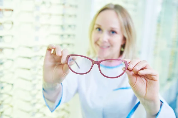 Optometrista látszerész, szemüveget a boltban — Stock Fotó