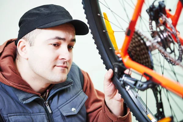 Serviceman installing assembling or adjusting bicycle gear on wh — Stock Photo, Image