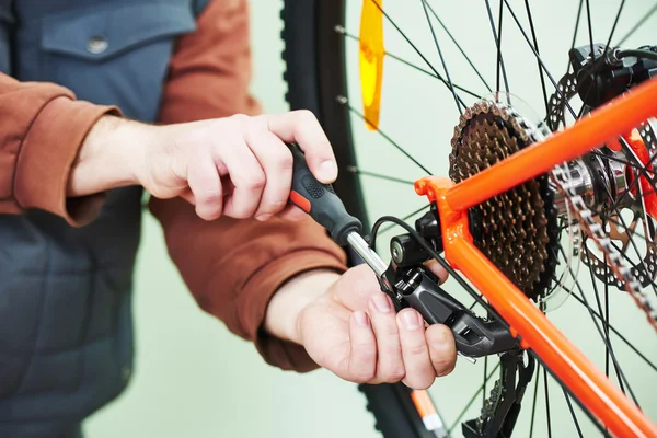 Serviceman installing assembling or adjusting bicycle gear on wh — Stock Photo, Image