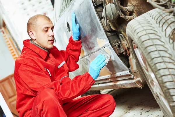 Trabajador que aplica la masilla de reparación de carrocería — Foto de Stock