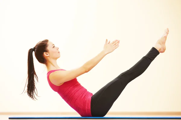Женщина делает упражнения на растяжку в тренажерном зале — стоковое фото