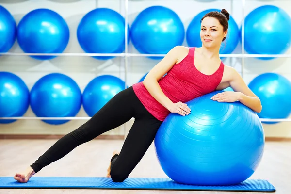 Kvinnan gör varma upp fitness boll övning — Stockfoto