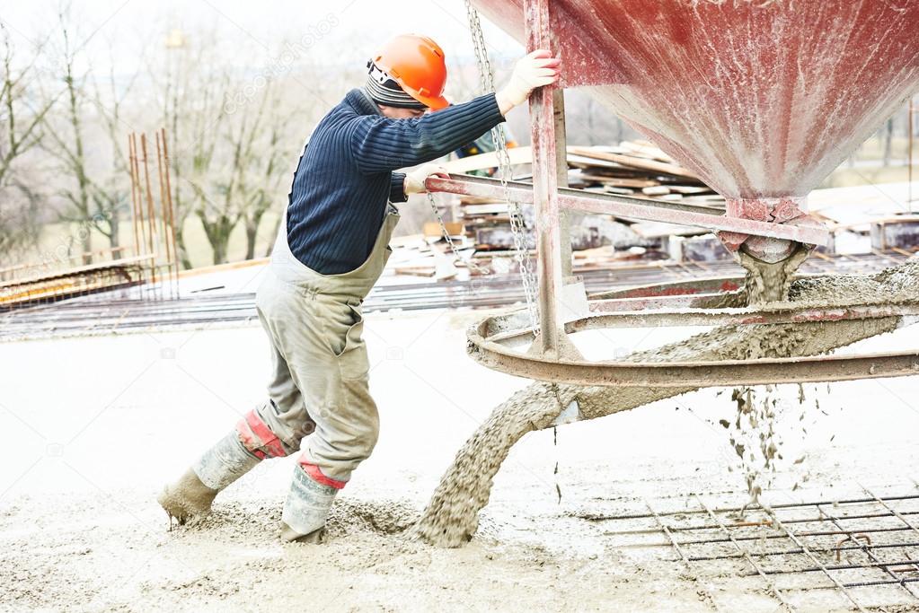 Worker during concrete pouring into formwork