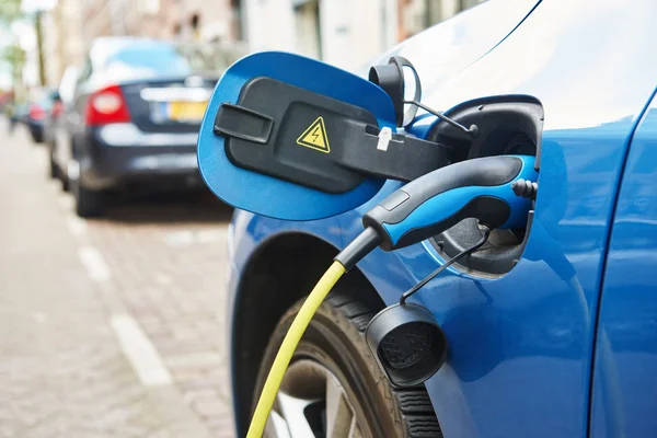 Power supply plugged into an electric car during charging — Stock Photo, Image