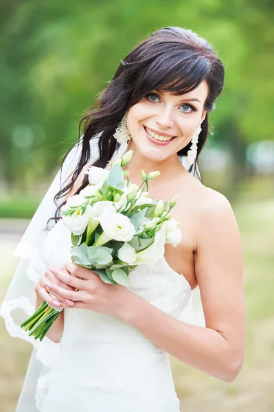 Fröhliche Braut mit frischem Blumenstrauß im Freien — Stockfoto