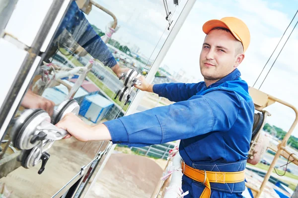 Builder installing glass windows on facade — Stock Photo, Image