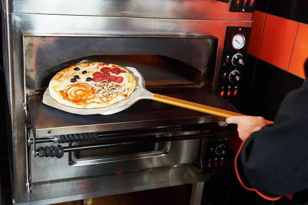 Chef boulanger cuisinier sortir la pizza du four — Photo