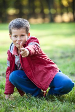 Genç beyaz çocuk kamerayı işaret ederek ateş ediyor.