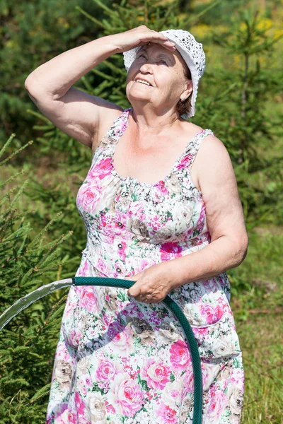 Zmęczona Starszy Biały Kobieta Stoi Podlewania Wąż — Zdjęcie stockowe