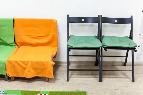 Battaniyeli Ahşap Kanepe Oturma Odasında Iki Siyah Sandalye Var — Stok fotoğraf