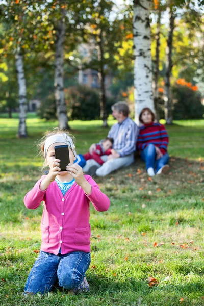 Jong Meisje Fotograferen Met Mobiele Telefoon Familie Zitten Gras Achtergrond — Stockfoto