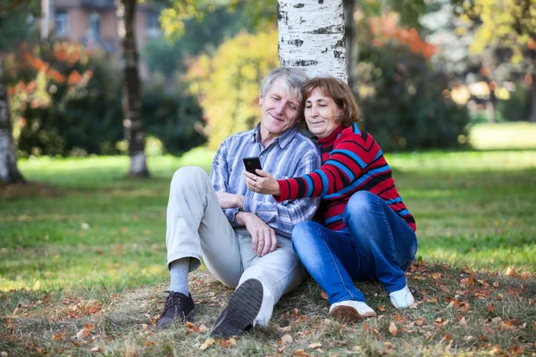 Pareja Mayor Sentada Juntos Haciendo Selfie Con Teléfono Celular Parque —  Fotos de Stock