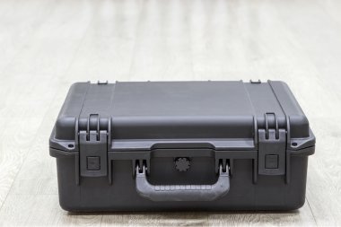 Kapalı plastik siyah koruyucu çanta yerde yatıyor.