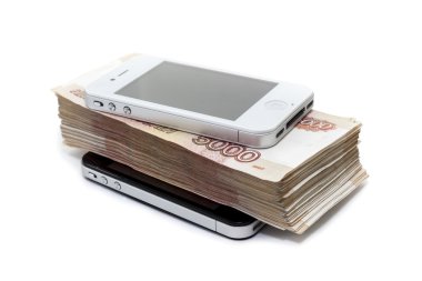 Beyaz arka planda iki akıllı telefonun arasında nakit para yatıyor.