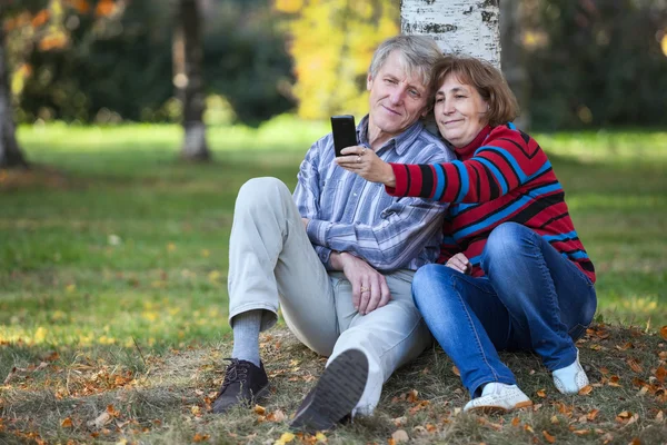 Olgun Beyaz Erkek Kadın Ağacın Altında Oturup Selfie Çekerken Gülümsüyorlar — Stok fotoğraf