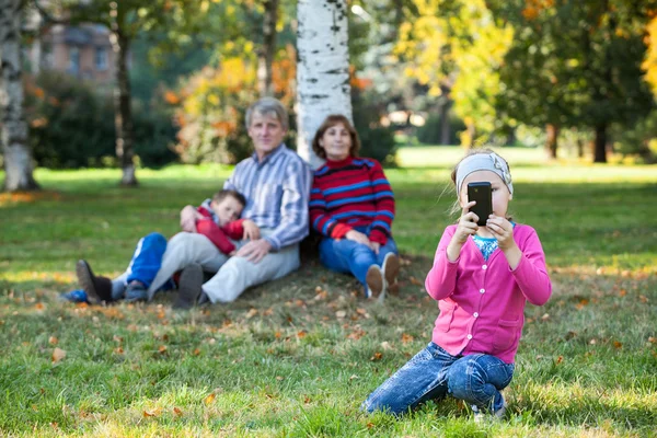Ευτυχισμένη Οικογένεια Είναι Στο Πάρκο Φθινόπωρο Καθιστώντας Εικόνα Στο Τηλέφωνο — Φωτογραφία Αρχείου