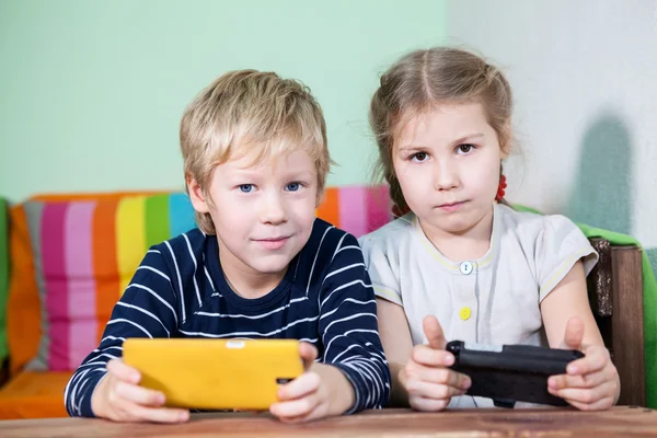 Dwoje Pięknych Białych Dzieciaków Smartfonami Rękach Patrzących Przed Kamerę — Zdjęcie stockowe