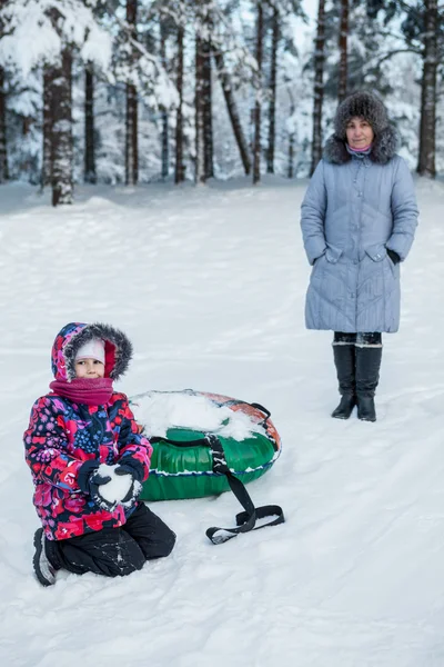 幸せな女の子とともに雪とともに母で冬スキーリゾートとともにチューブ — ストック写真