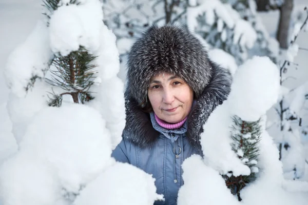 코카서스 여자의 얼굴은 겨울에 눈덮인 소나무 가지로 — 스톡 사진