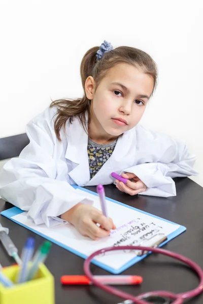 Menina Casaco Branco Médico Sentado Mesa Olhando Para Câmera — Fotografia de Stock