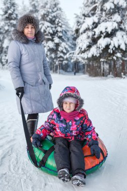 Mutlu anne ve kızın portresi kışın metroyla gezintiye çıkıyor.