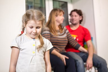 Mutlu ebeveynlerin arka planında üzgün bir çocuk, ailede yeni bir baba