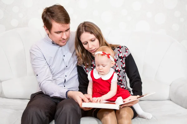 Padre Madre Cercando Leggere Libro Loro Bambina — Foto Stock