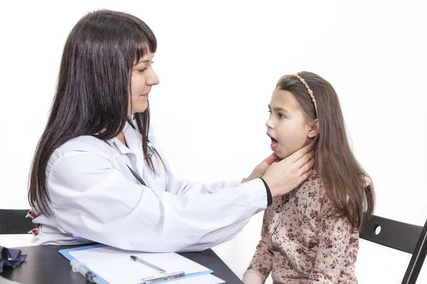 女儿科医生检查儿童咽喉时检查 背景为白色 — 图库照片