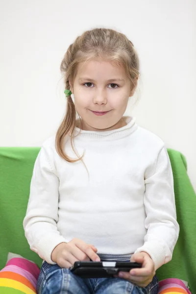 Hübsches Kaukasisches Mädchen Sitzt Mit Smartphone Und Schaut Die Kamera — Stockfoto
