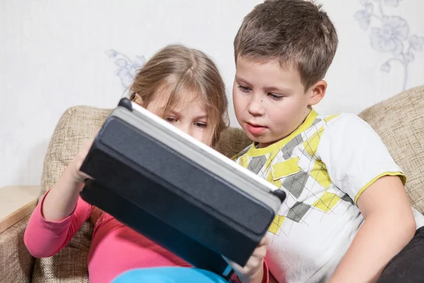 Jogando Crianças Sentadas Sofá Juntos Segurando Tablet Com Jogos Interessantes — Fotografia de Stock