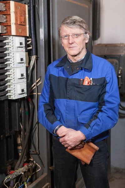 Älterer Kaukasischer Elektriker Blauer Uniform Steht Der Nähe Eines Hochspannungskastens — Stockfoto