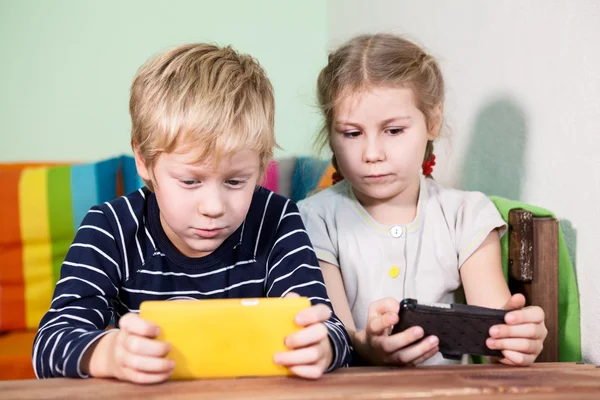 Dos Niños Caucásicos Que Juegan Con Teléfonos Celulares — Foto de Stock