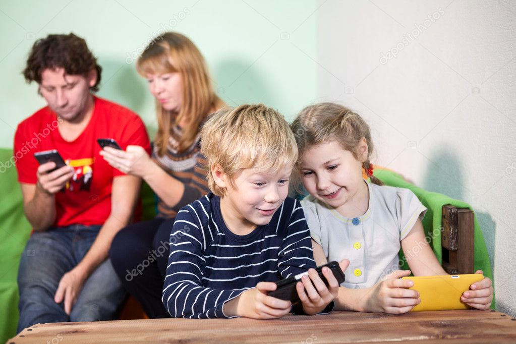 Caucasian children and parents playing games on smartphones